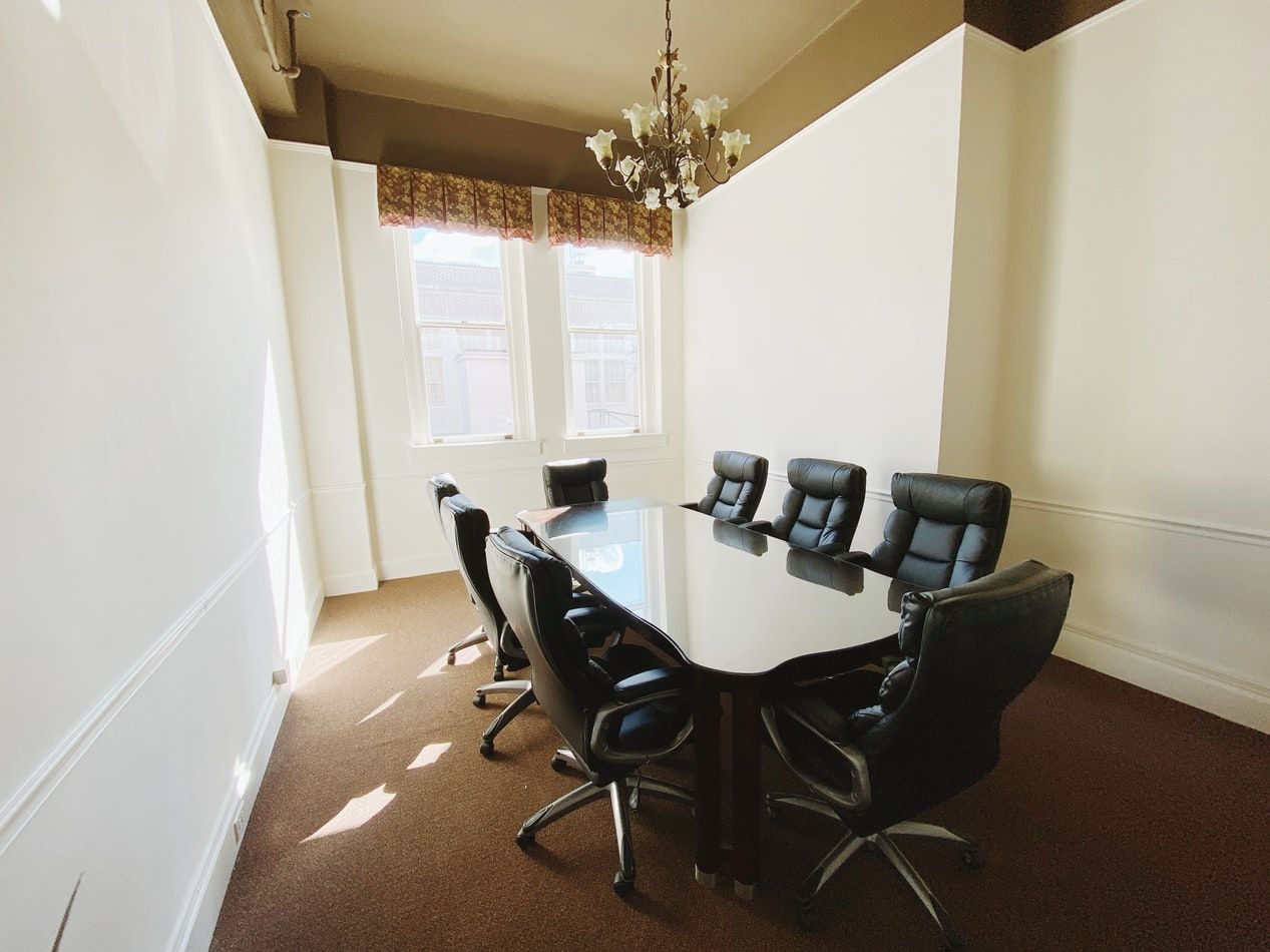A conference room with a long table and chairs and a chandelier.