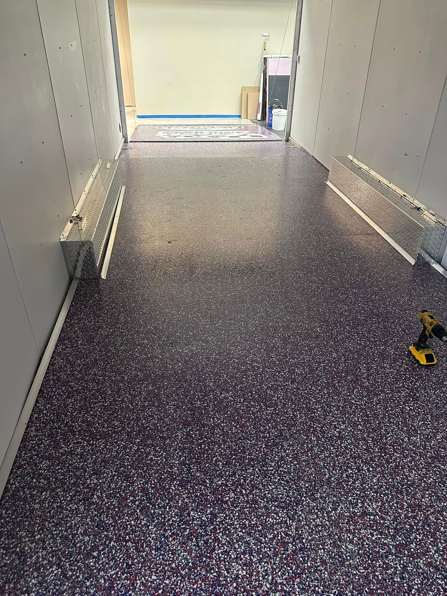 A narrow hallway with a glittery purple floor, white walls, and bright light at the end.