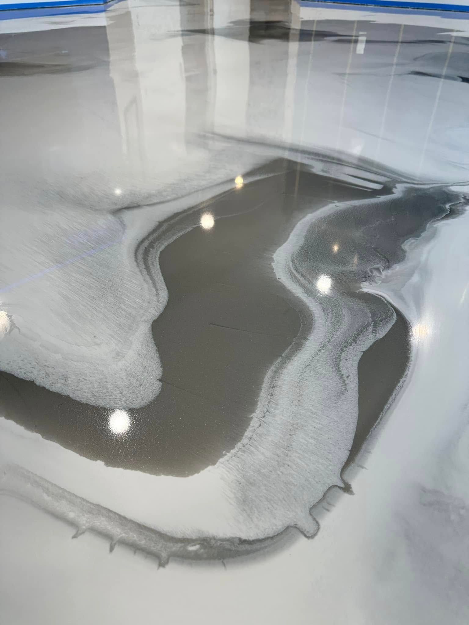 Swirling gray and white epoxy floor with shiny, reflective surface.