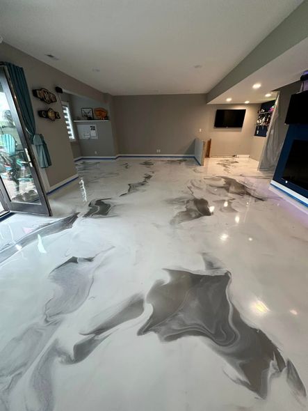 Room with a white and gray marbled epoxy floor, walls are gray, and a blue fireplace.