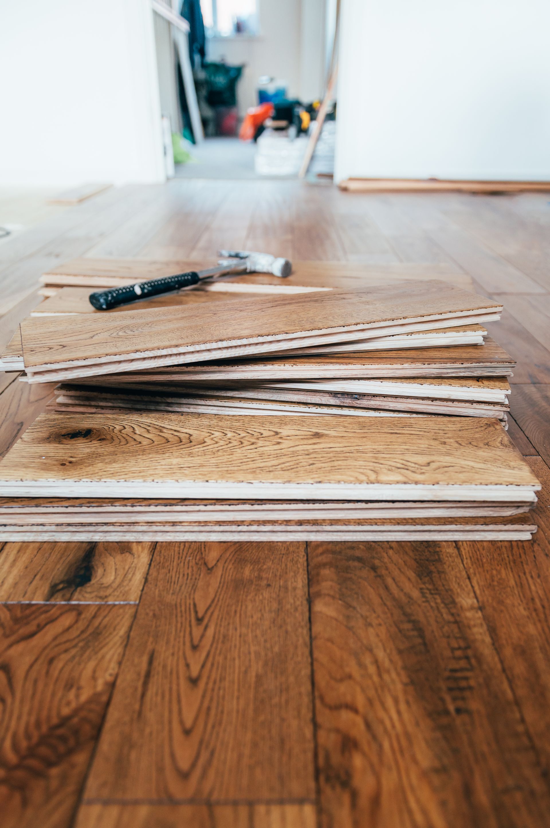 A stack of wooden flooring boards sitting on top of each other on a wooden floor.