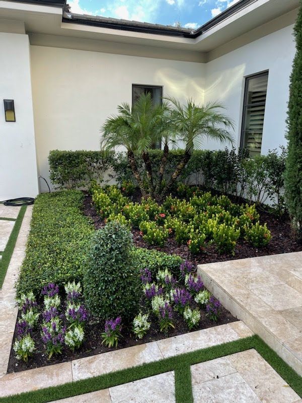 A well-landscaped garden with various green shrubs and colorful flowers.