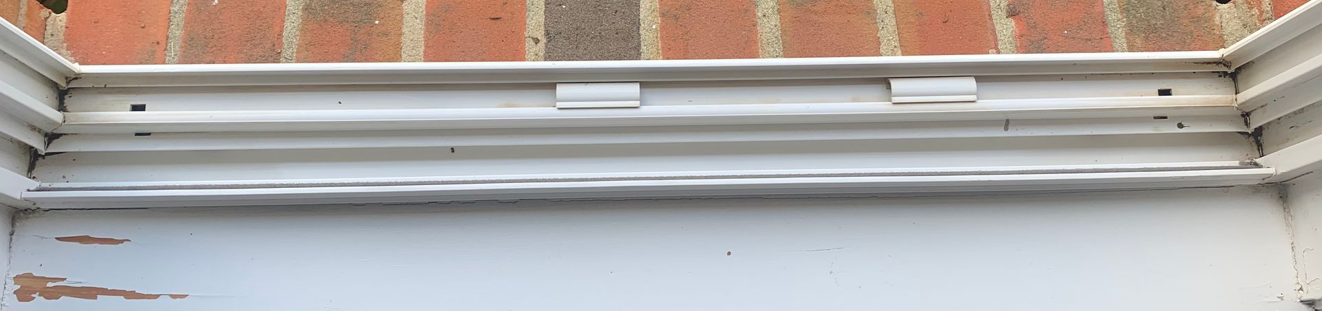 White window frame against a red brick wall.