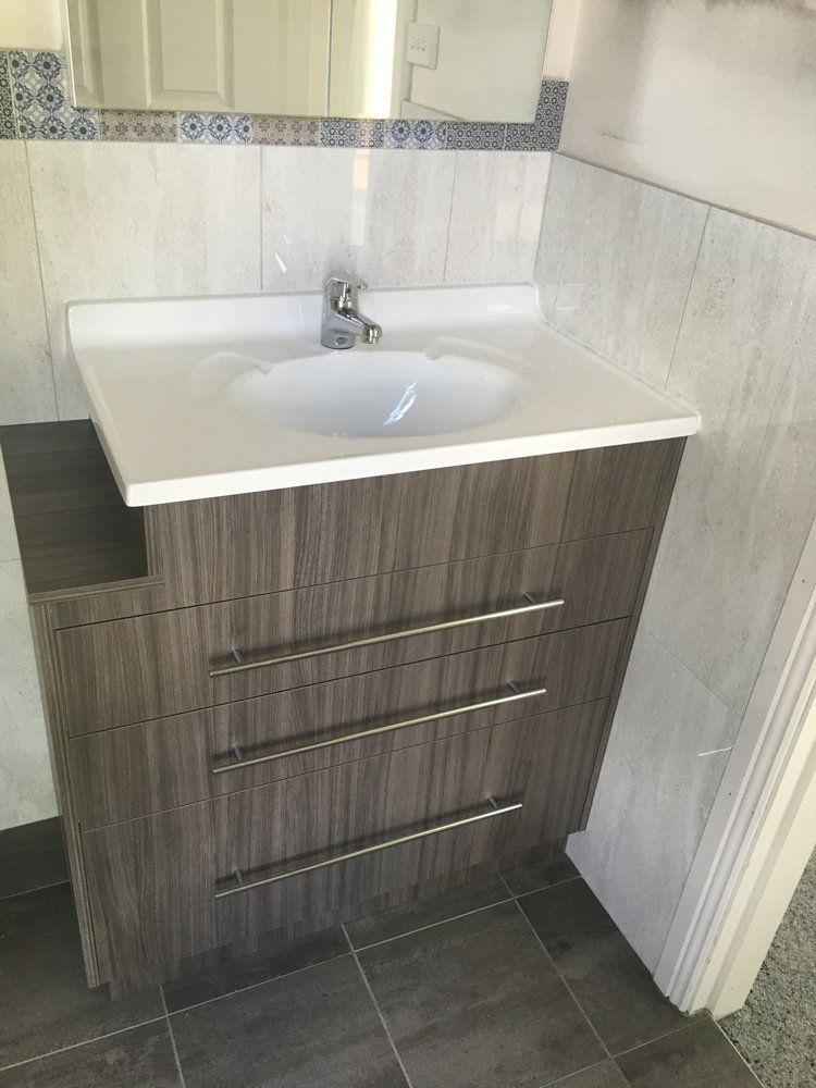 A Bathroom Vanity With a Sink and a Mirror — Hey Presto Kitchens & Renovations in Armidale, NSW