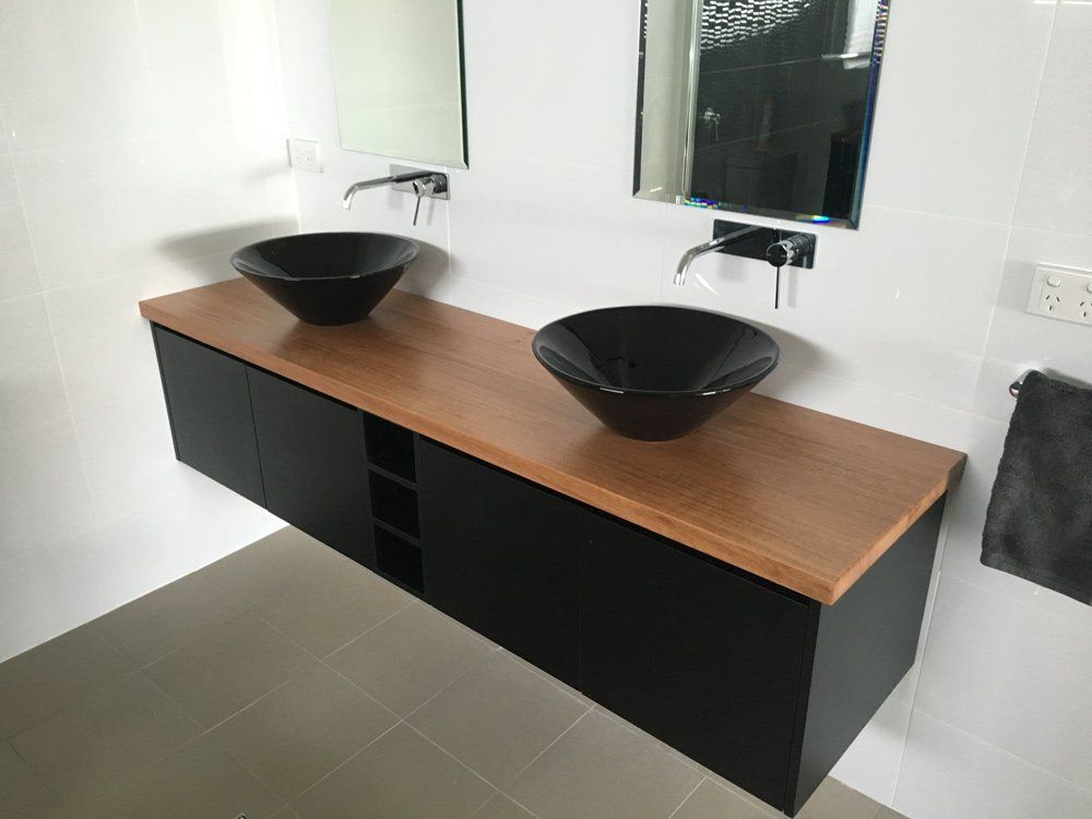 Two Black Sinks Are on a Wooden Counter in a Bathroom — Hey Presto Kitchens & Renovations in Armidale, NSW