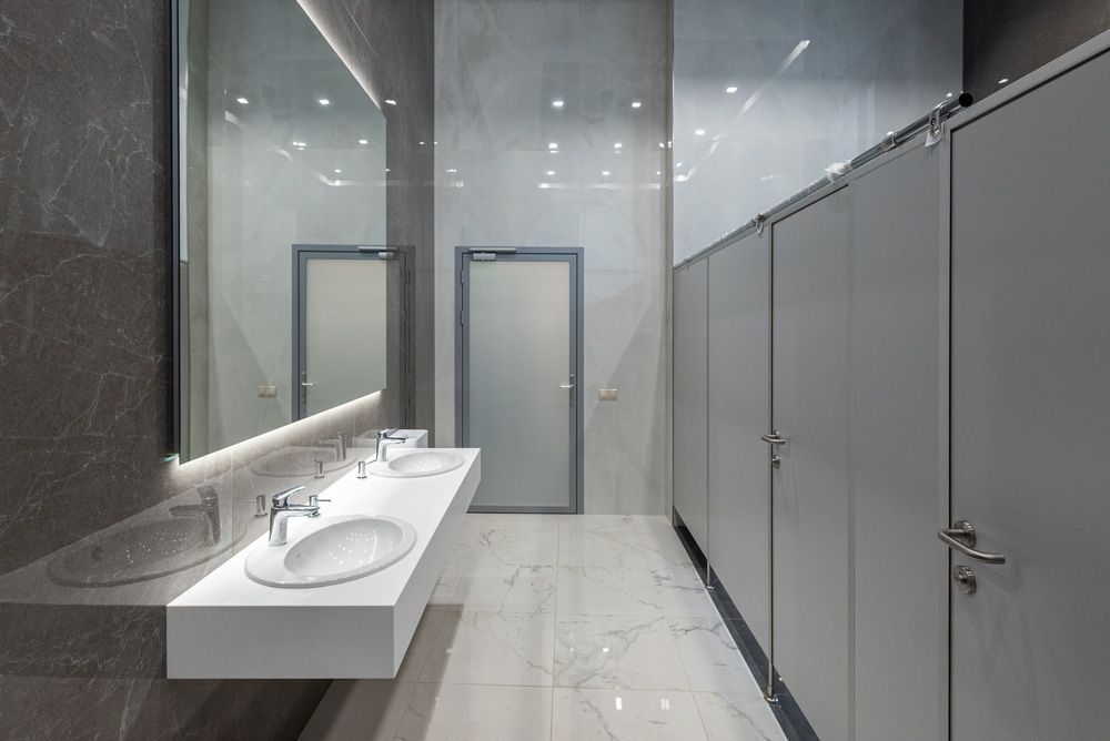A Public Restroom With Two Sinks and a Mirror — Hey Presto Kitchens & Renovations in Armidale, NSW