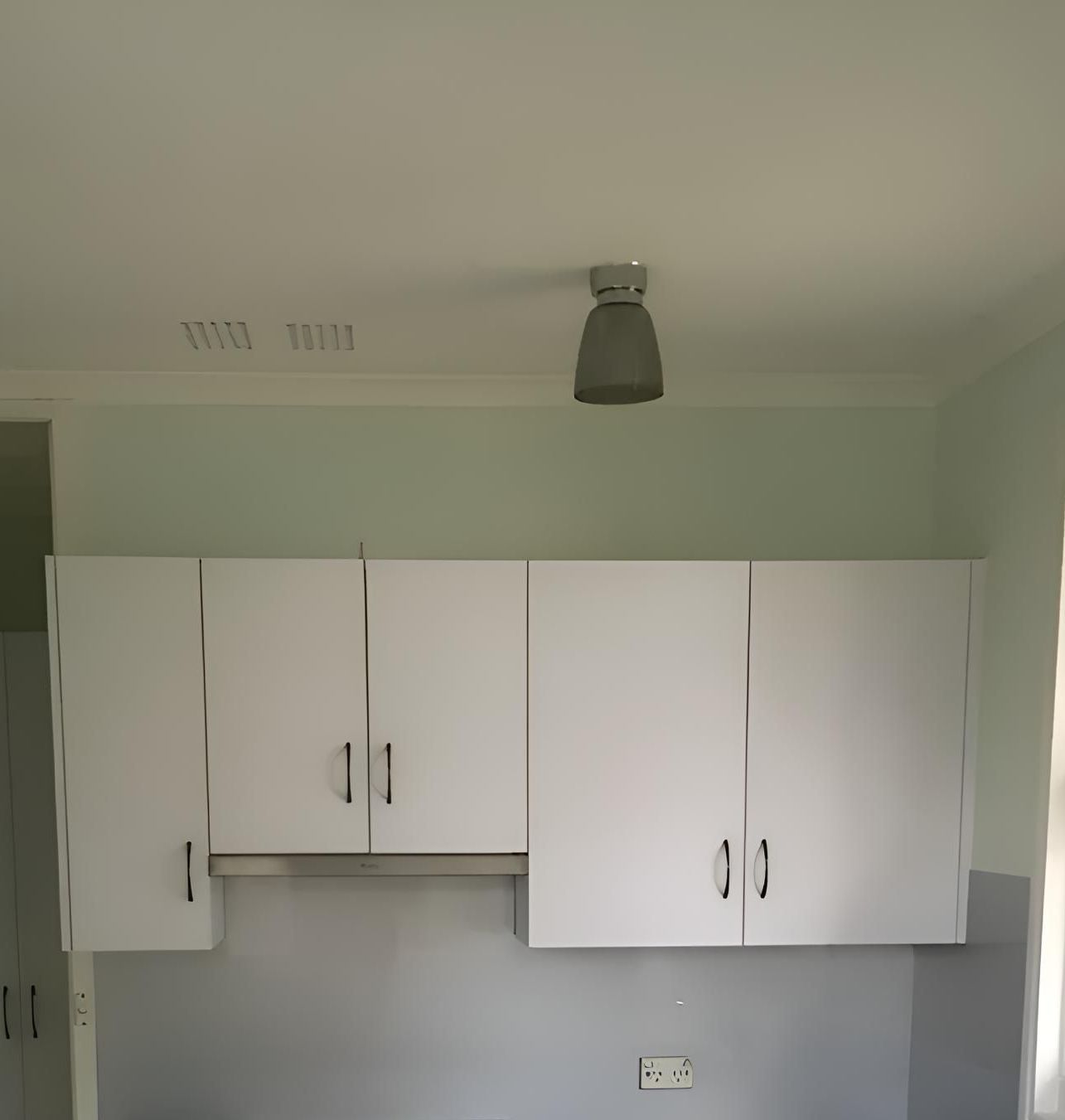 A Kitchen With White Cabinets And A Light On The Ceiling — Hey Presto Kitchens & Renovations in Armidale, NSW