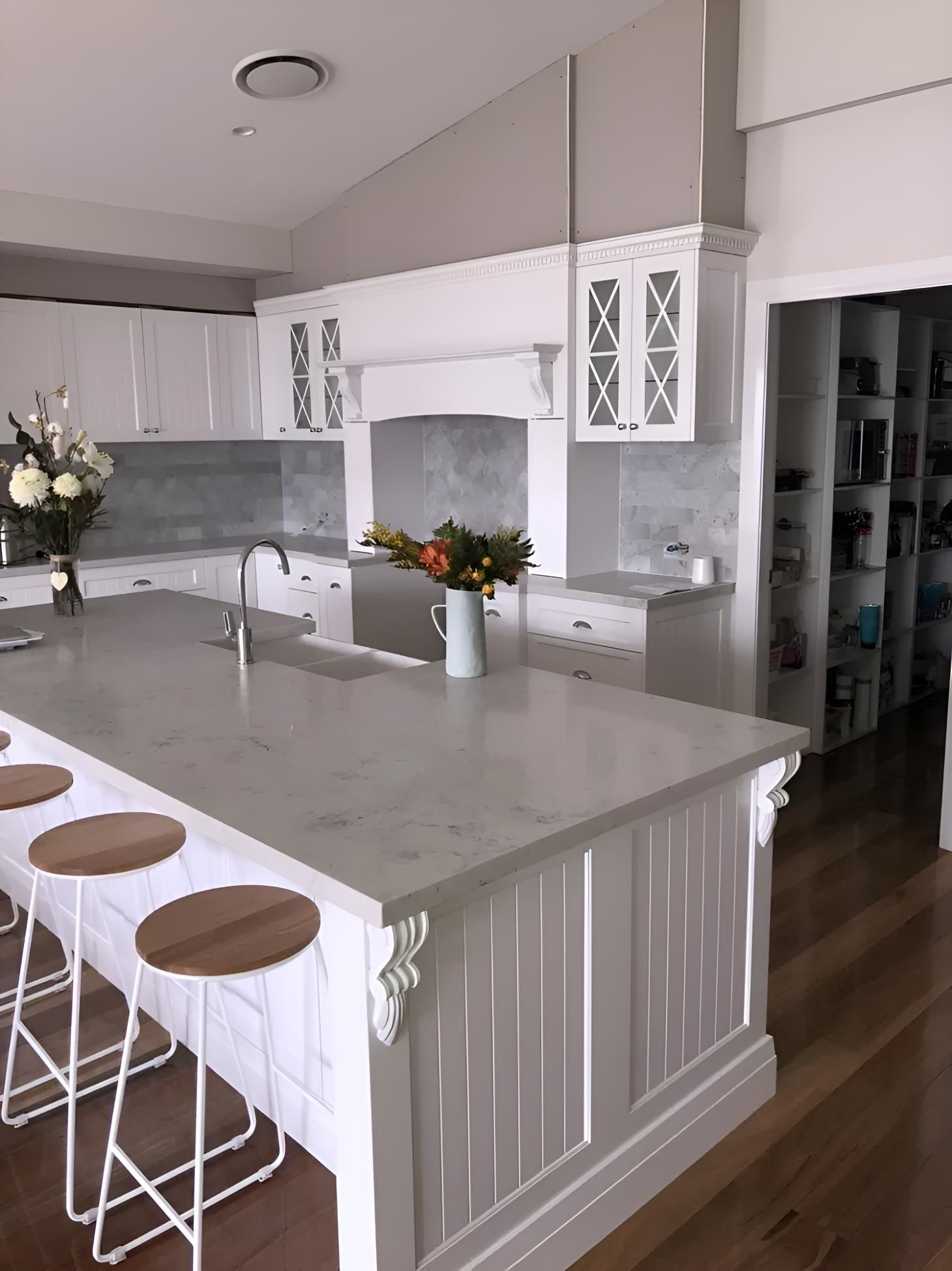 A Kitchen With White Cabinets And A Large Island With Stools — Hey Presto Kitchens & Renovations in Armidale, NSW