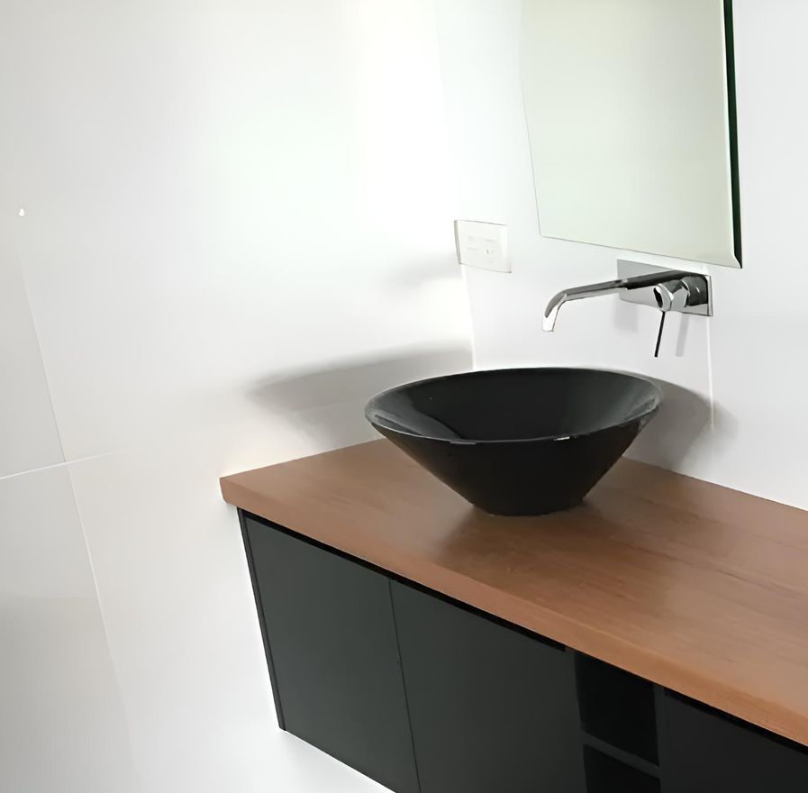 A Bathroom With A Black Sink And A Mirror — Hey Presto Kitchens & Renovations in Uralla, NSW