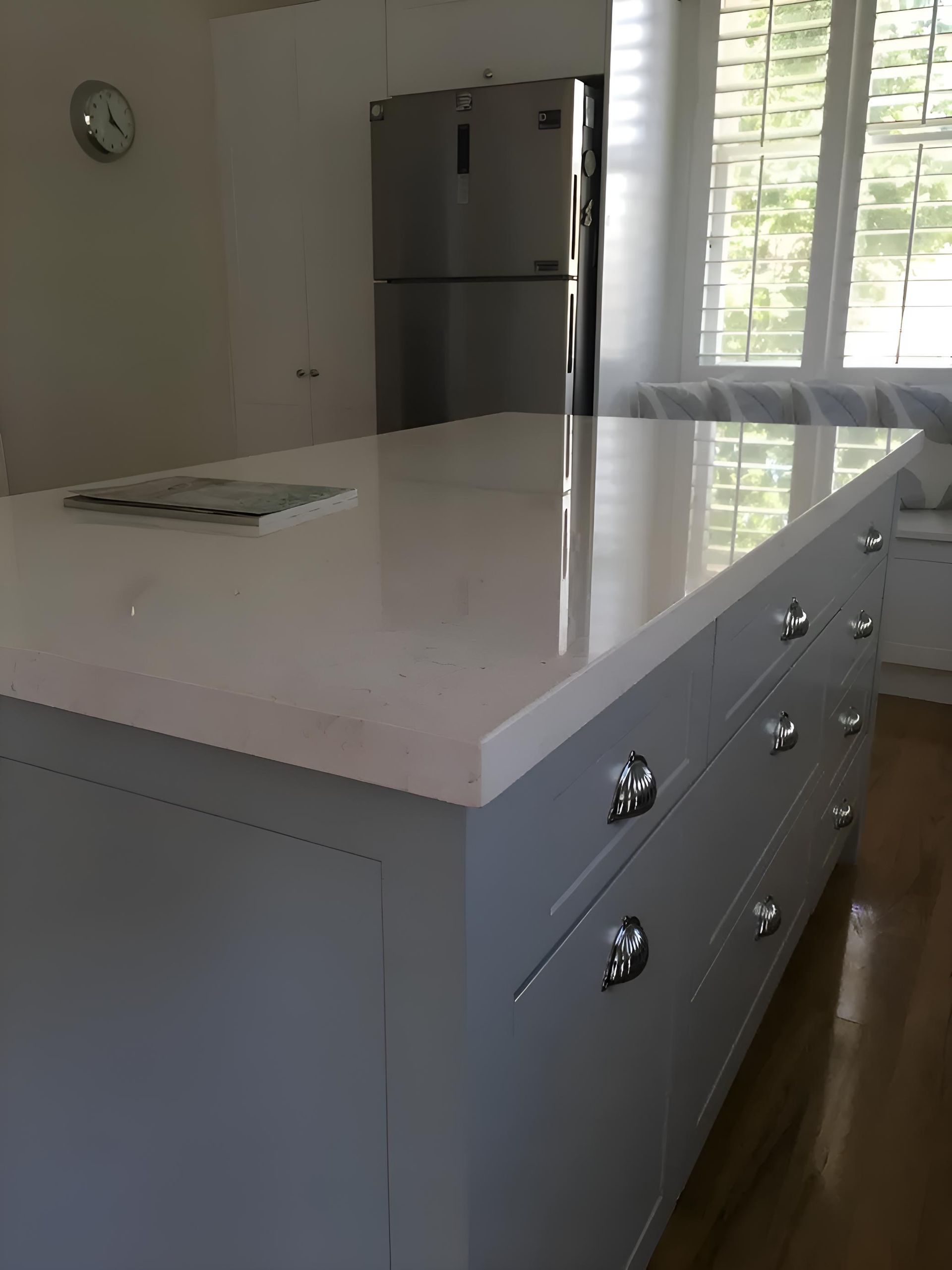 A Kitchen With A Large Island And A Clock On The Wall — Hey Presto Kitchens & Renovations in Armidale, NSW