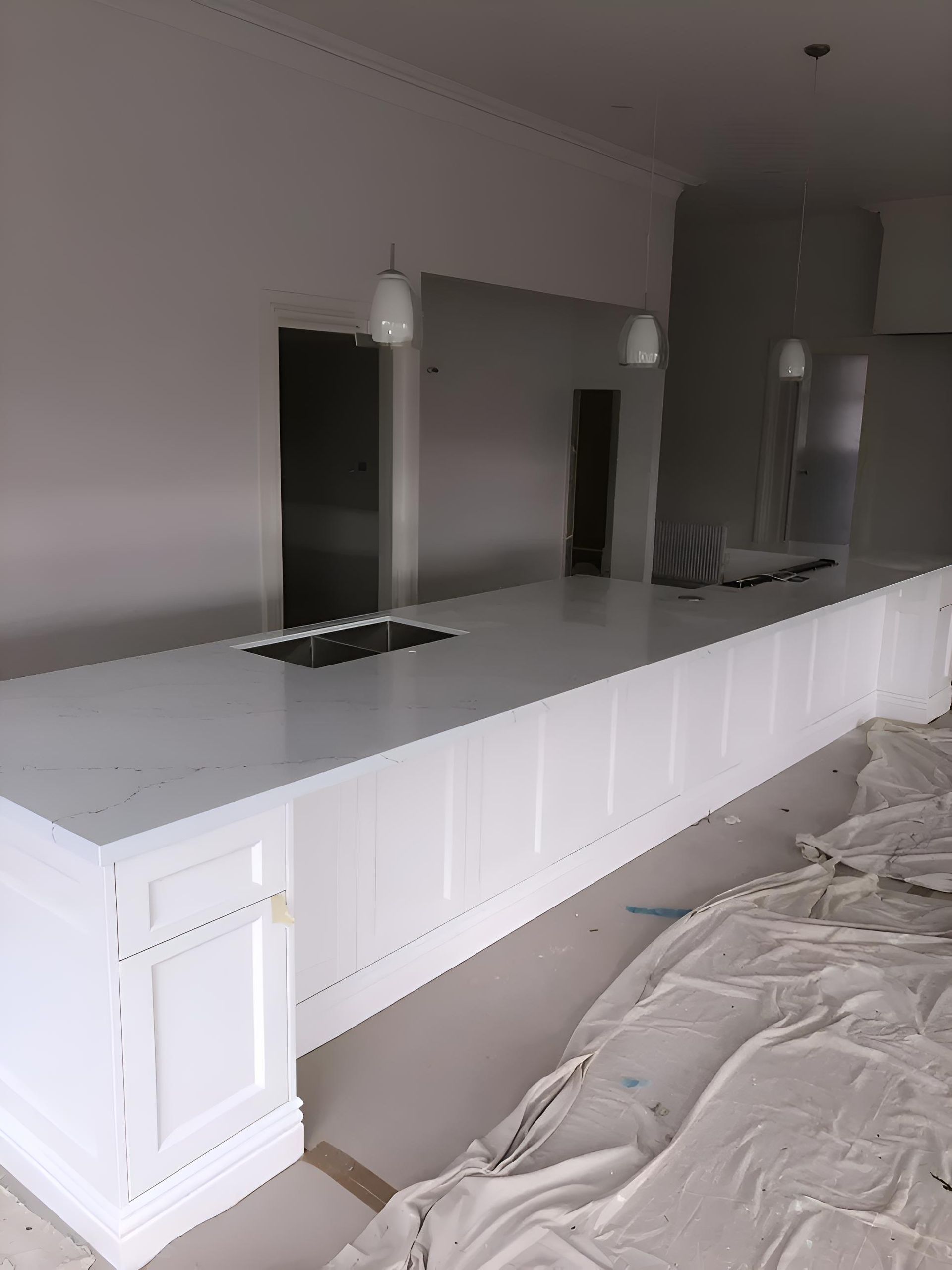 A Long White Counter In A Kitchen With A Sink — Hey Presto Kitchens & Renovations in Armidale, NSW