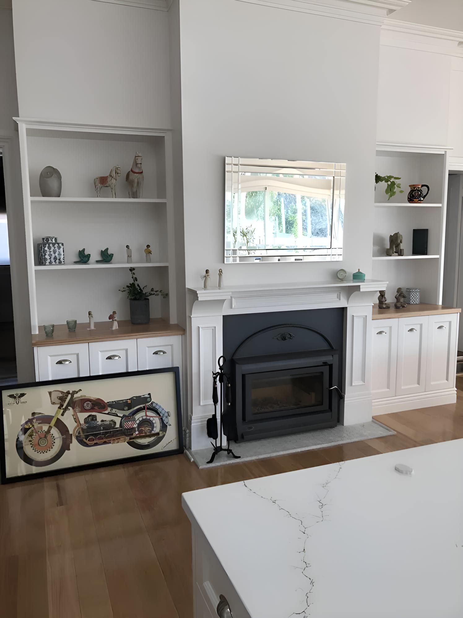 A Living Room With A Fireplace And A Picture Of A Motorcycle On The Wall — Hey Presto Kitchens & Renovations in Armidale, NSW