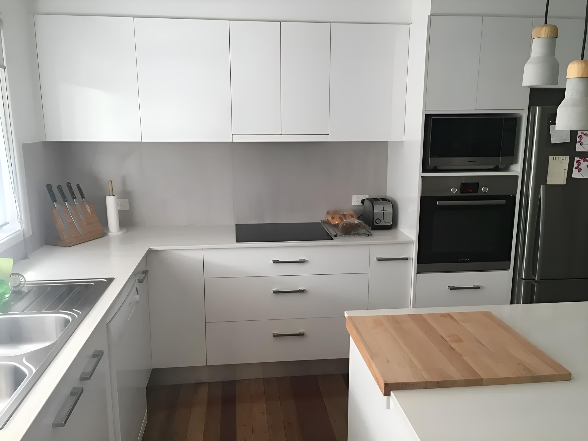 A Kitchen With White Cabinets And A Wooden Cutting Board — Hey Presto Kitchens & Renovations in Armidale, NSW