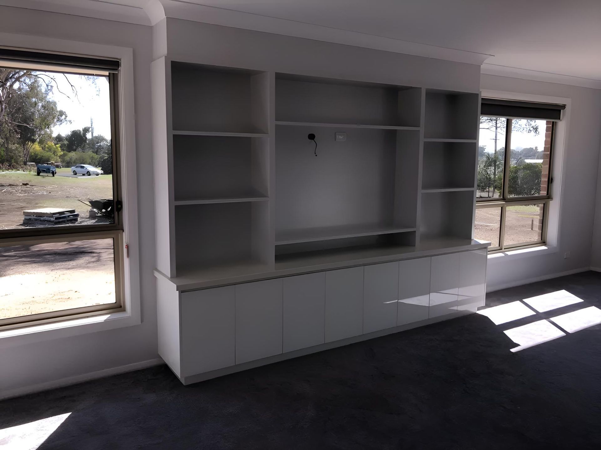 A Living Room With A Large Entertainment Center And Shelves — Hey Presto Kitchens & Renovations in Guyra, NSW
