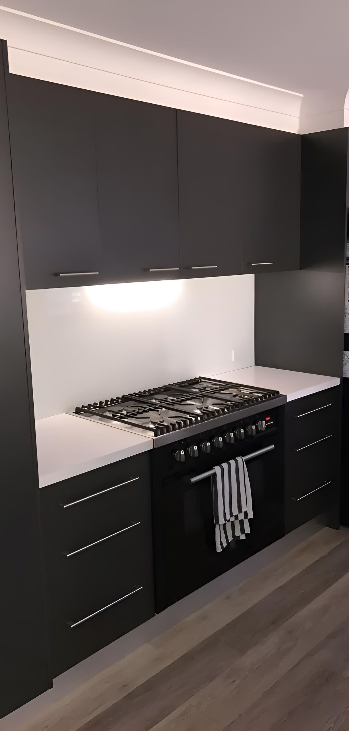 A Kitchen With Black Cabinets And A Stove Top Oven — Hey Presto Kitchens & Renovations in Armidale, NSW