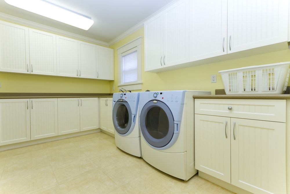 A Laundry Room With Two Washers and Two Dryers — Hey Presto Kitchens & Renovations in Armidale, NSW