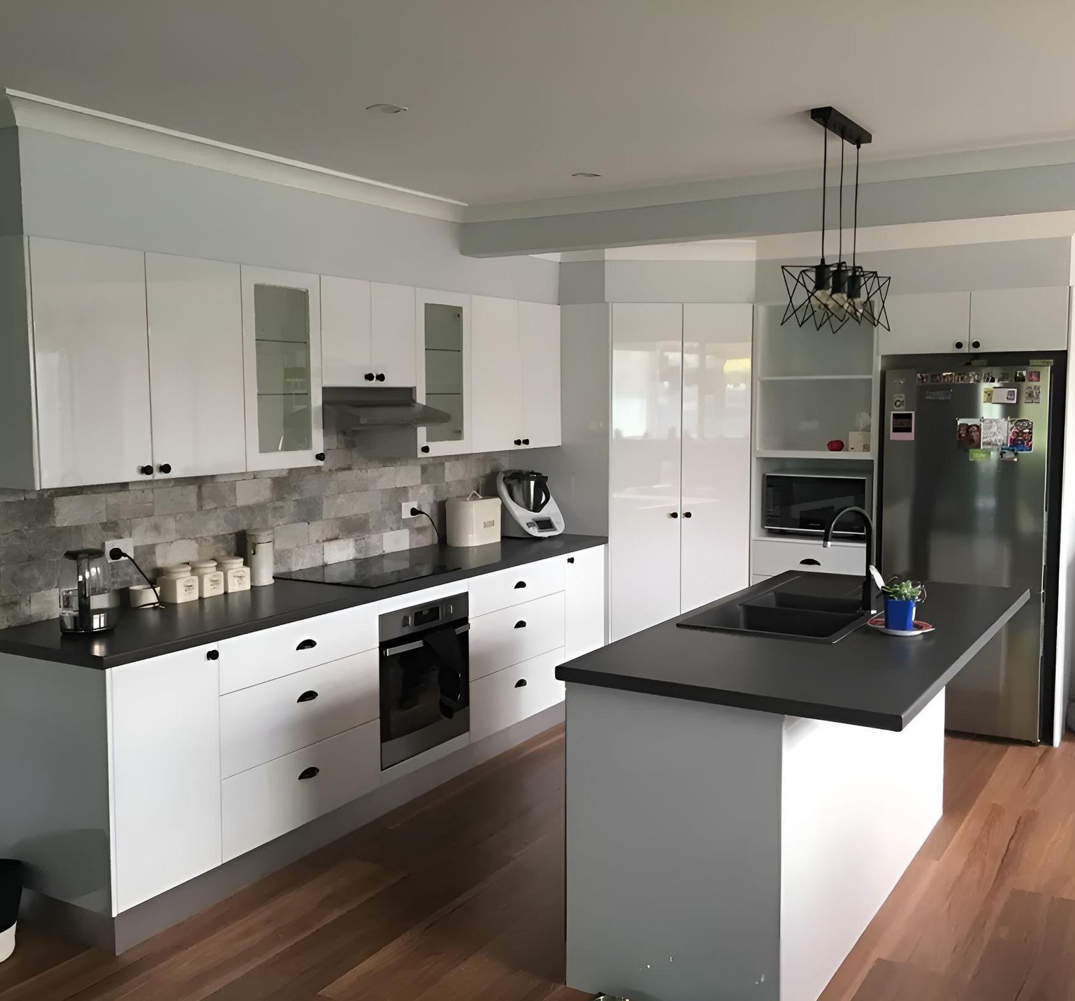 A Kitchen With White Cabinets And Black Counter Tops — Hey Presto Kitchens & Renovations in Armidale, NSW