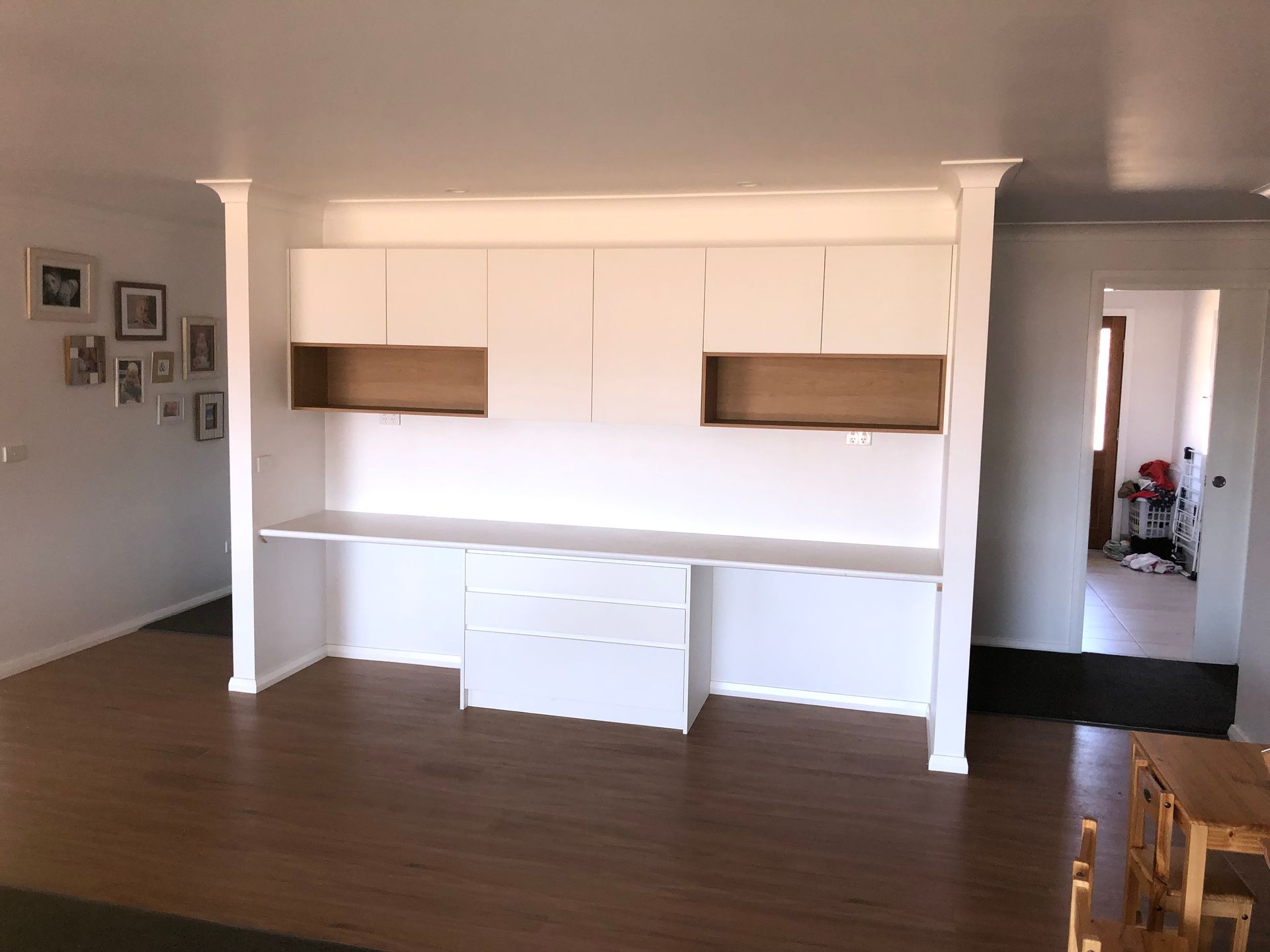 A Large Empty Room With a Wooden Floor and White Cabinets — Hey Presto Kitchens & Renovations in Armidale, NSW