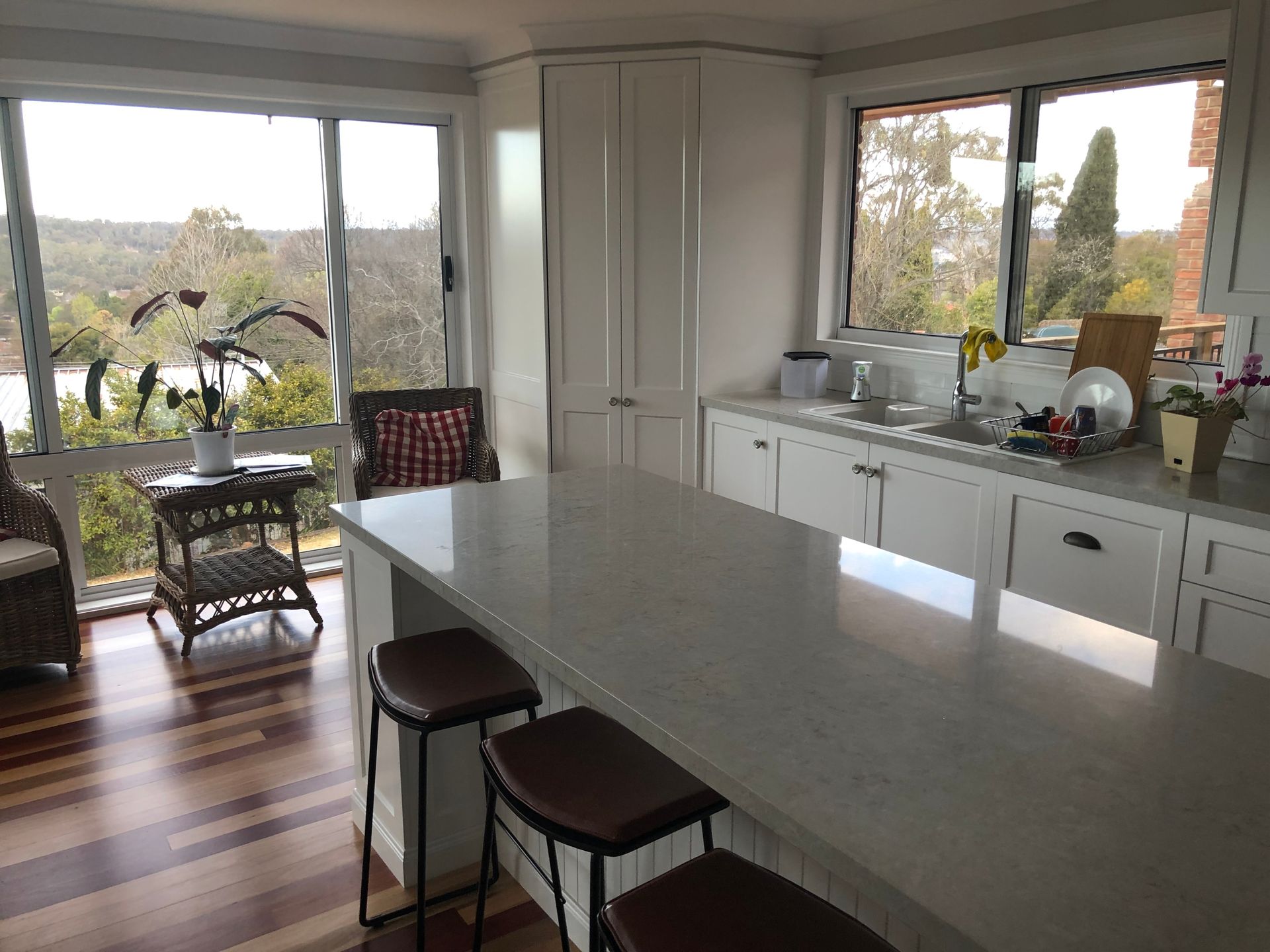 A Kitchen With a Large Island and Stools and a Large Window — Hey Presto Kitchens & Renovations in Armidale, NSW
