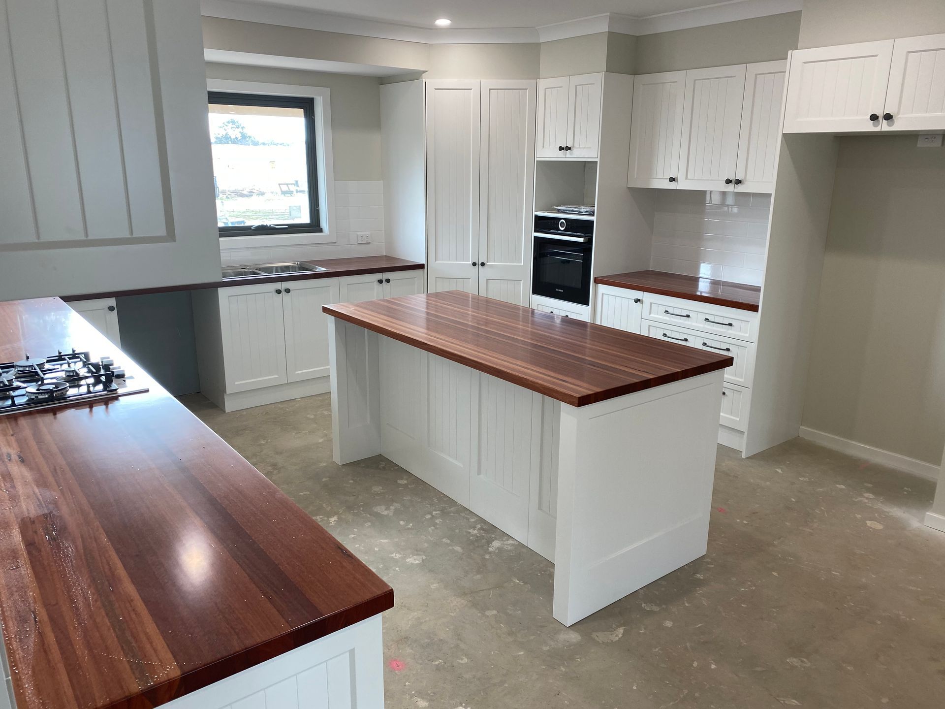 A Kitchen With White Cabinets and a Large Wooden Island — Hey Presto Kitchens & Renovations in Armidale, NSW