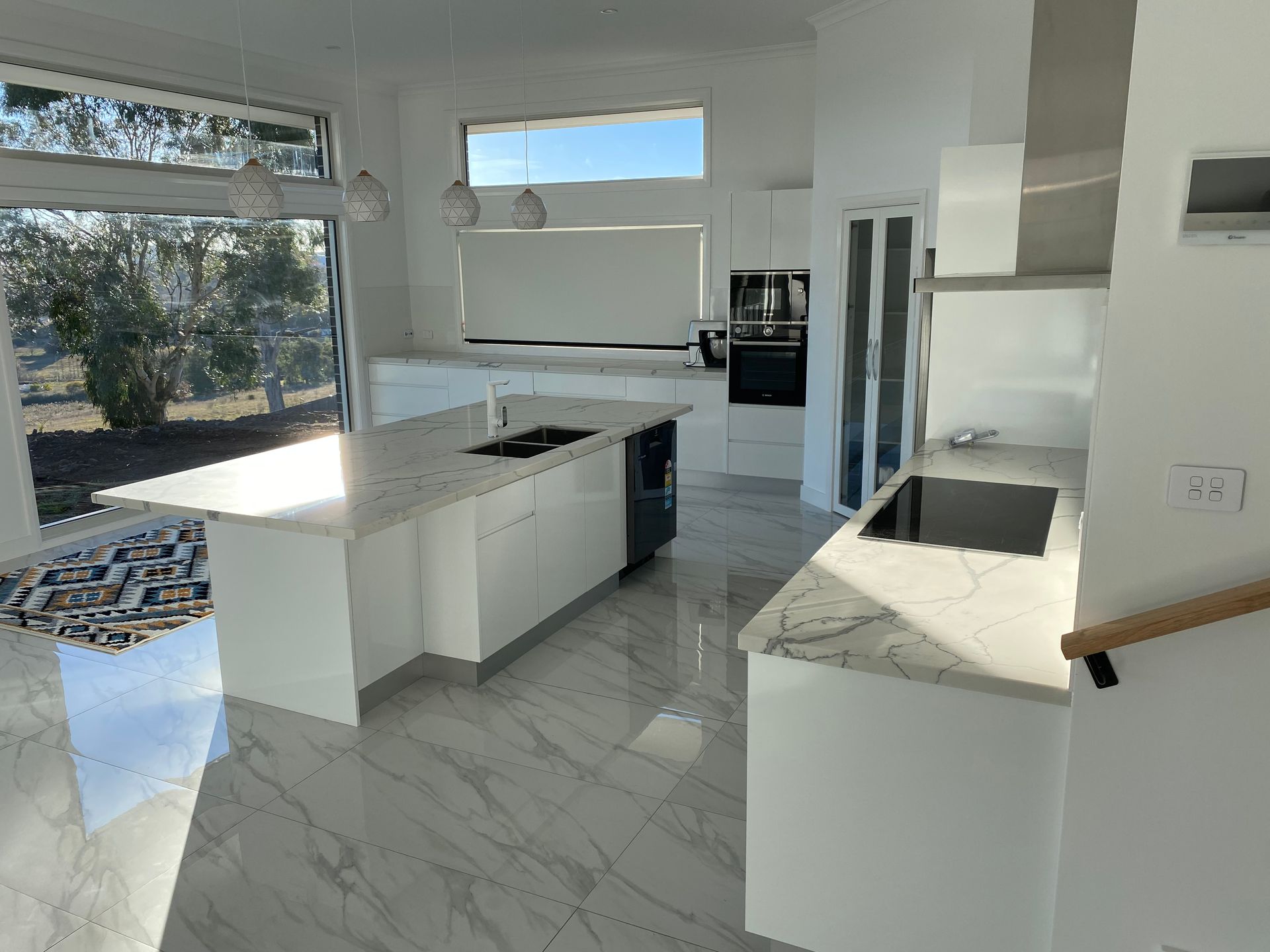 A Kitchen With White Cabinets, Marble Counter Tops and Large Island — Hey Presto Kitchens & Renovations in Armidale, NSW