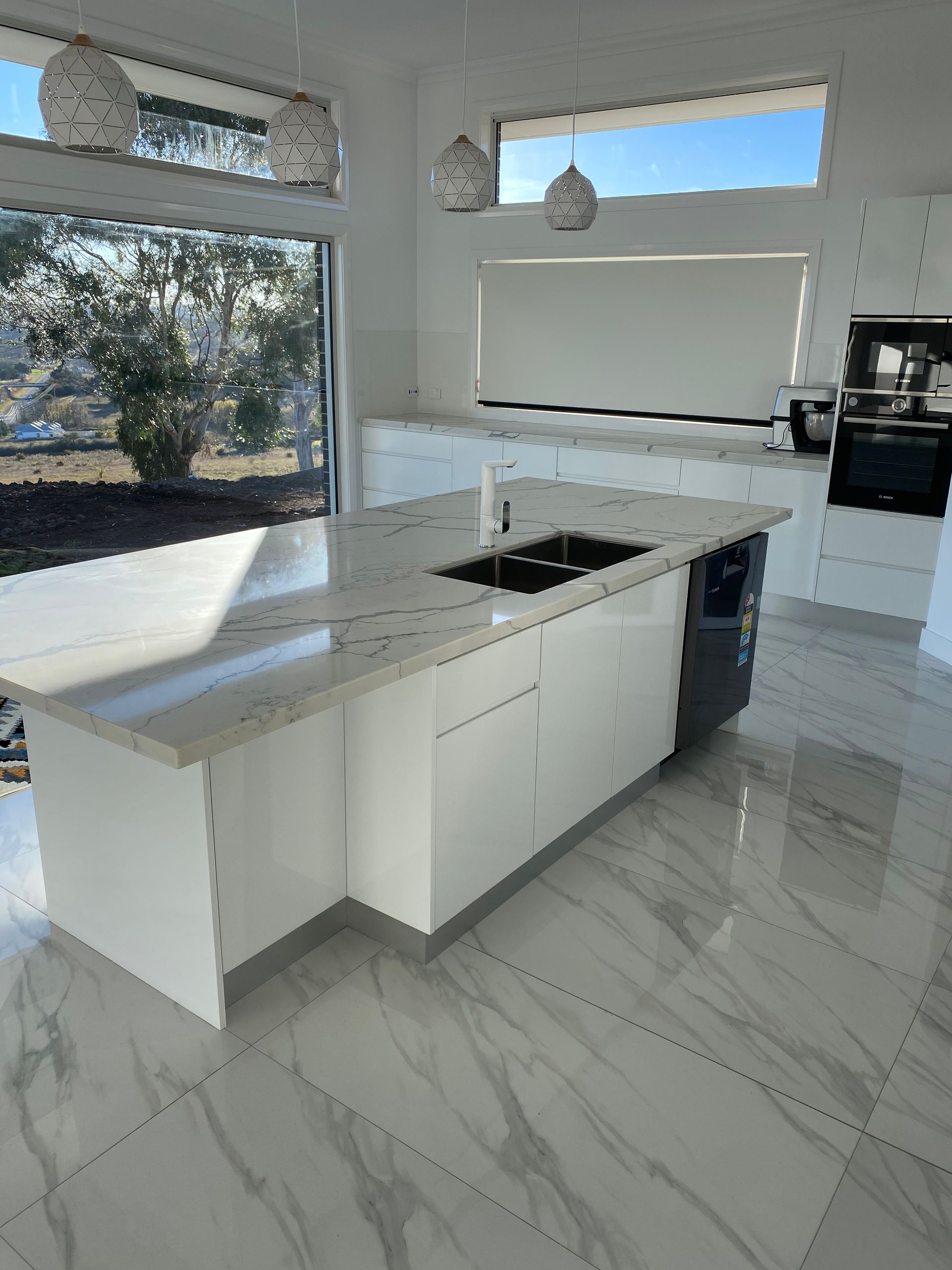 A Kitchen With White Cabinets, Granite Counter Tops, and a Large Island — Hey Presto Kitchens & Renovations in Armidale, NSW