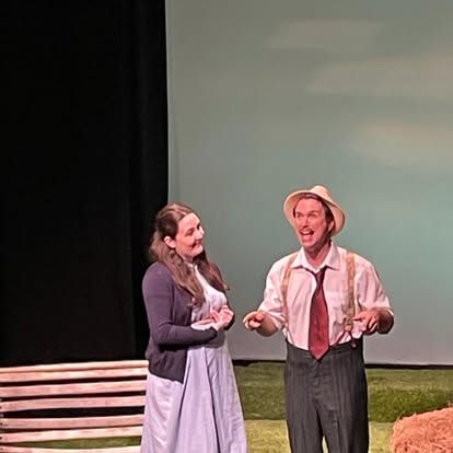 A man and a woman are standing next to each other on a stage.