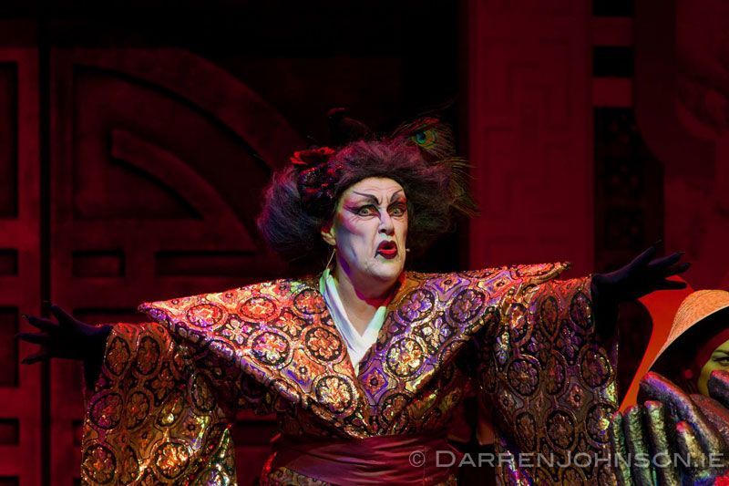 A drag queen is wearing a kimono on a stage.