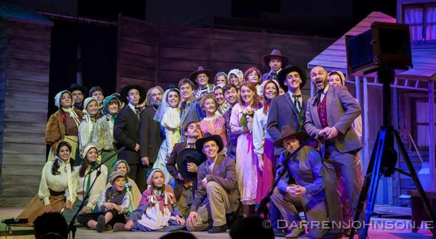 A large group of people are posing for a picture on a stage.