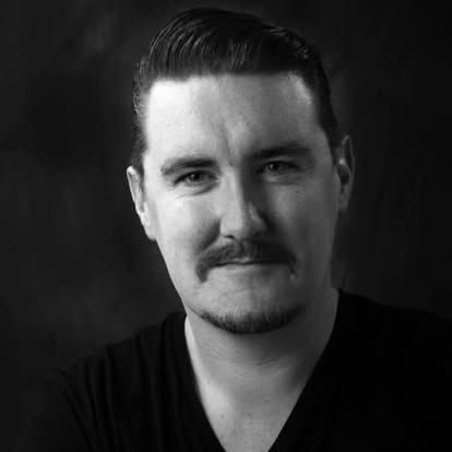 A black and white photo of a man with a beard and mustache.