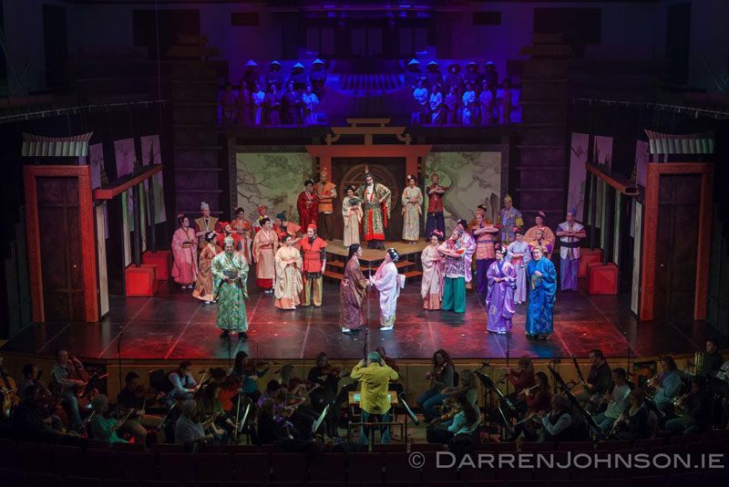 A group of people are standing on a stage in front of a crowd.