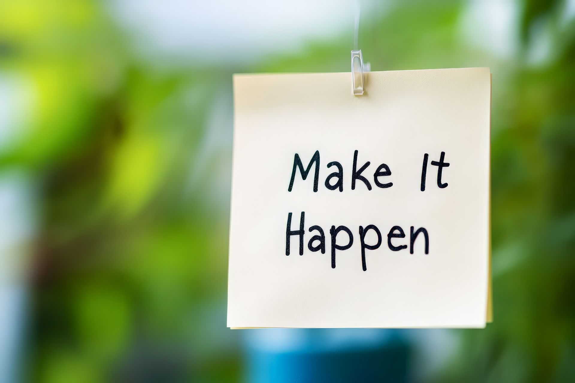A note that says `` make it happen '' is hanging on a clothespin.