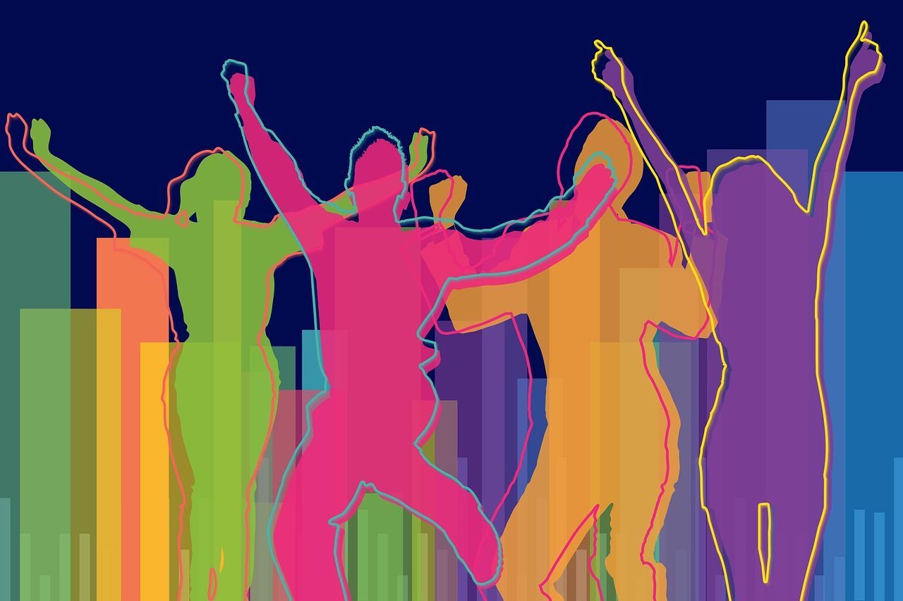 A group of people are dancing together with their arms in the air.