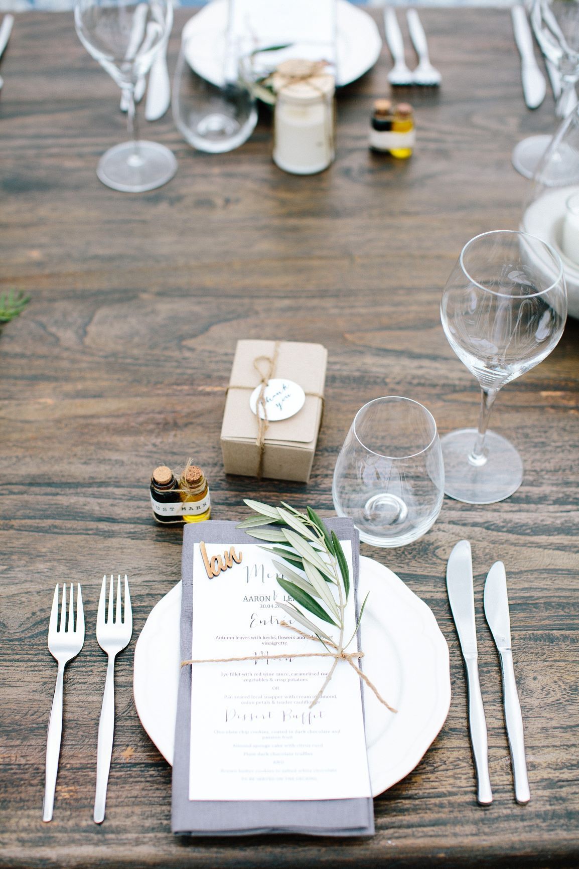 A Wooden Table With Plates, Forks, Knives, Wine Glasses And A Menu On It — Wedding & Event Hire In Byron Bay, NSW