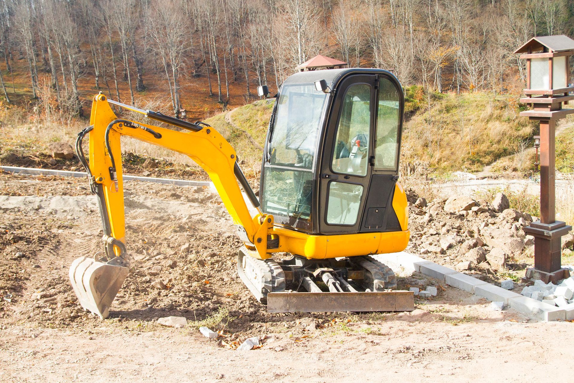 Escavatore giallo che scava in una zona sterrata