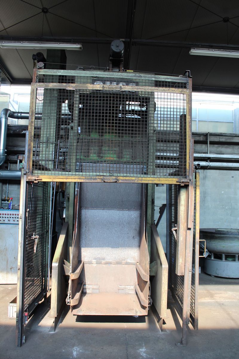 Gabbia metallica industriale con porte apribili, adatta a magazzini o stabilimenti di produzione.