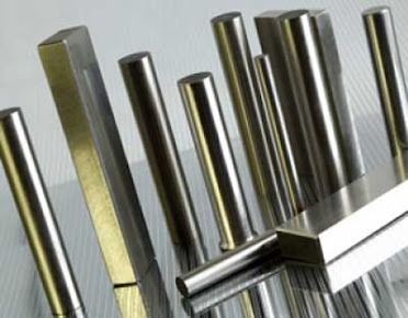 Barre e aste metalliche lucide disposte in fila su una superficie riflettente