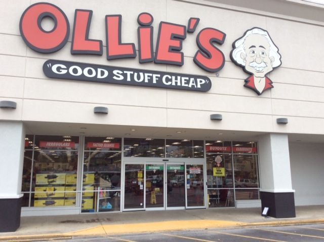 Ollie's Bargain Outlet storefront with red text and a cartoon caricature sign, 
