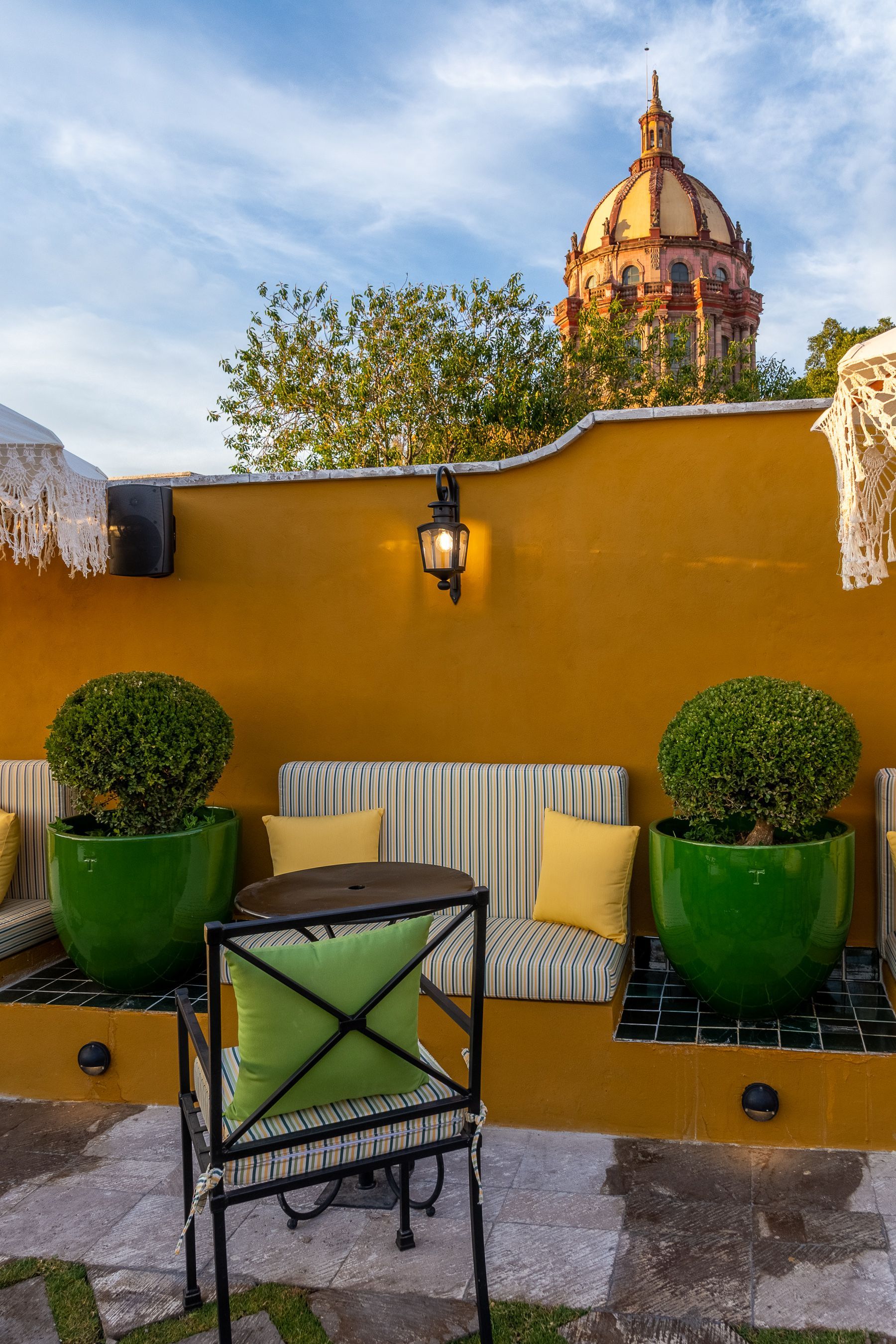 Un patio con sofá, silla, mesa y plantas en macetas.