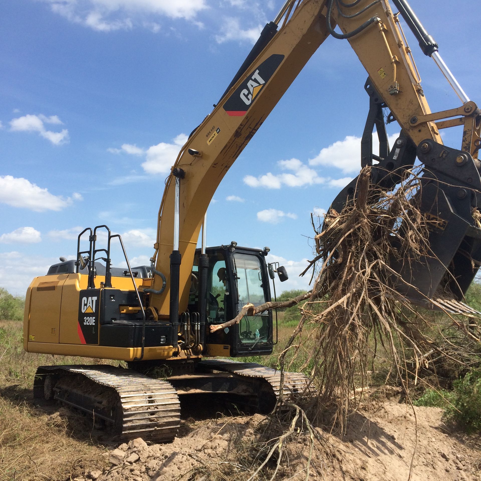 A yellow excavator is digging a hole in the dirt