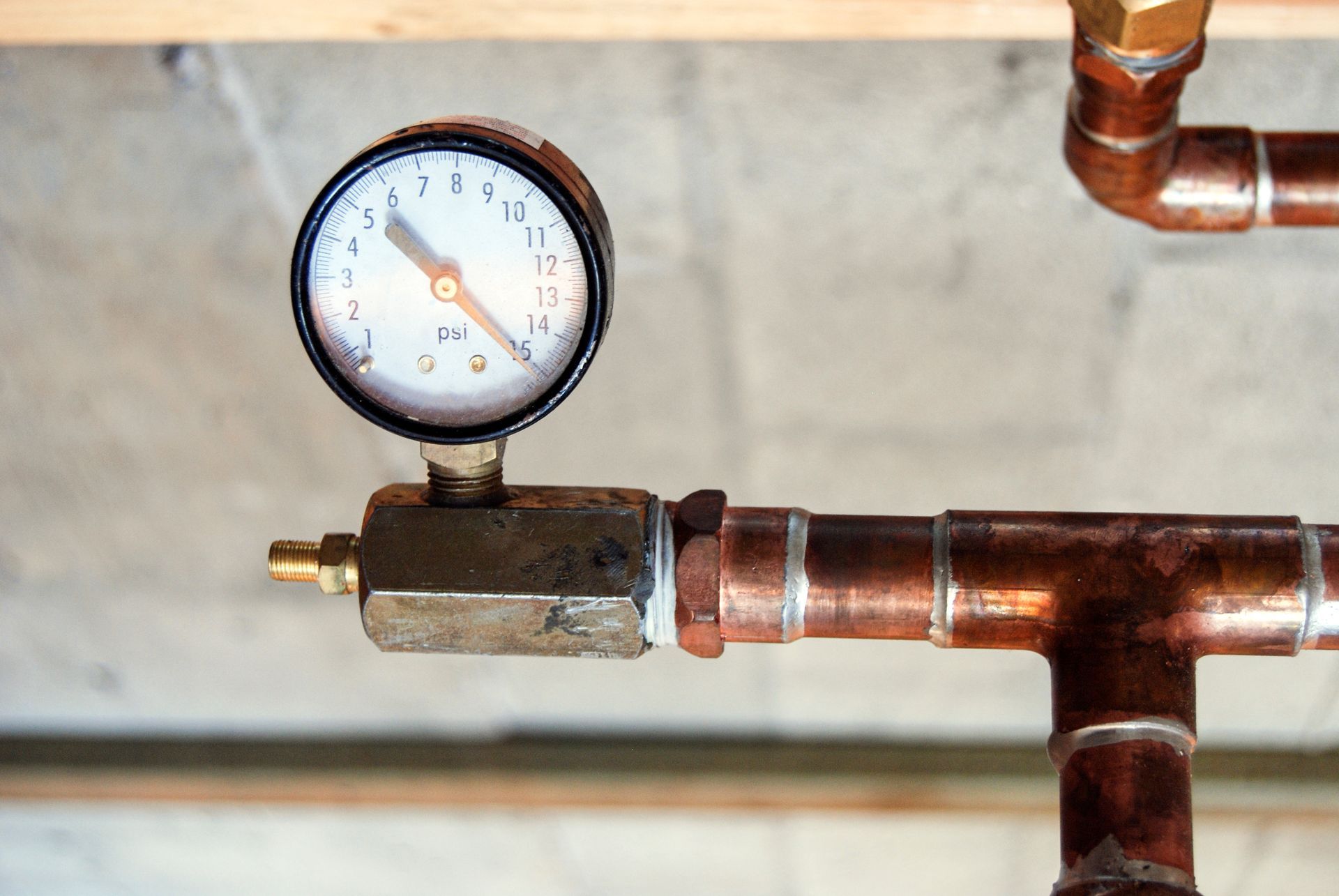 Pressure gauge attached to copper pipes, reading around 10 psi. Pressure gauge attached to copper pipes, reading around 10 psi.