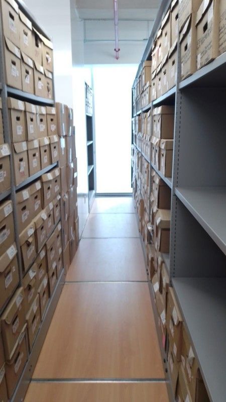 Un largo pasillo lleno de muchas cajas de cartón en estanterías.