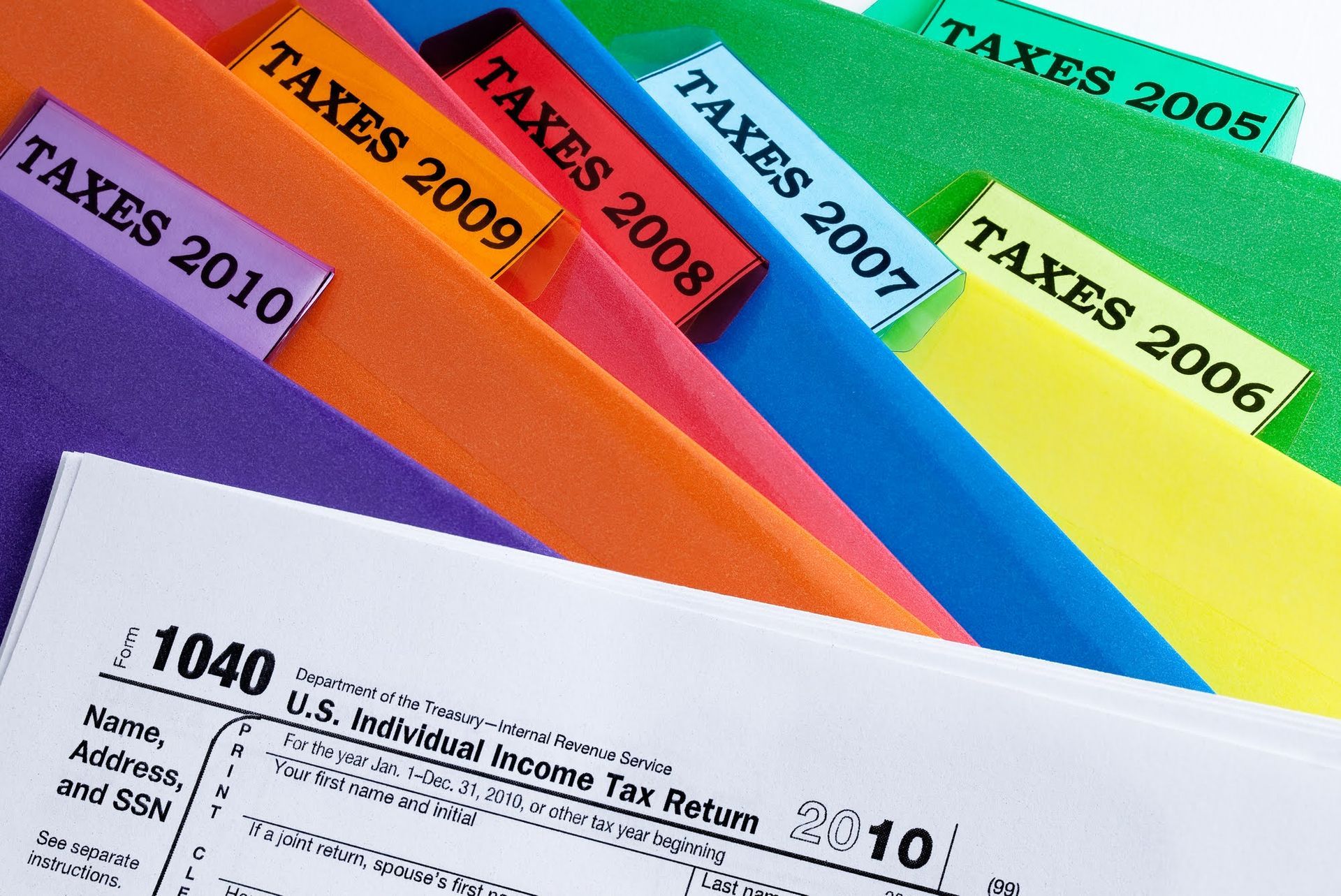 Tax documents in colorful file folders, labeled with tax years 2005-2010.