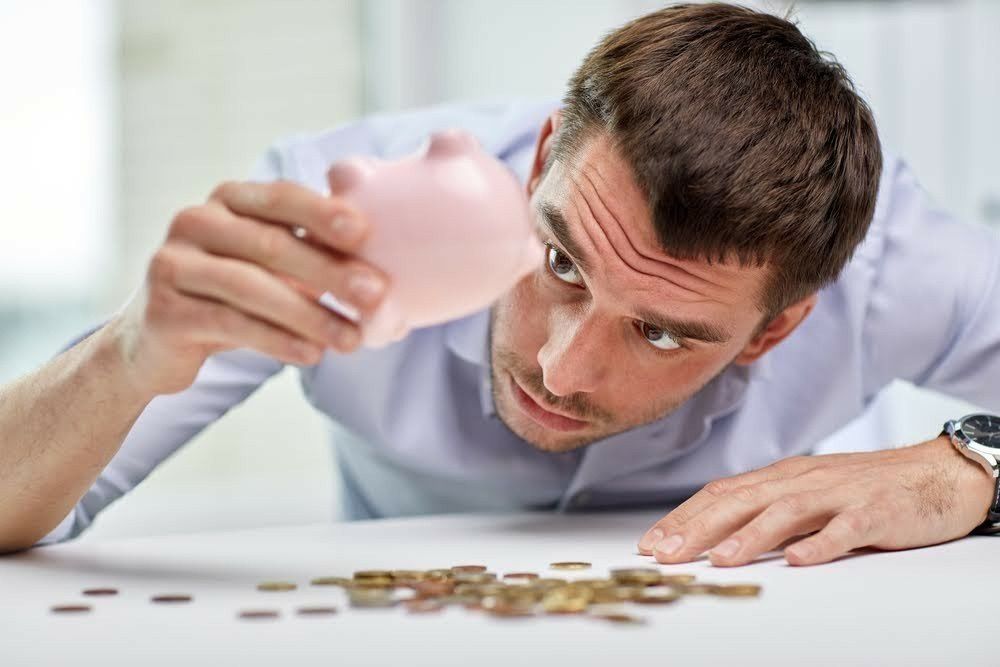 Man Looking At The Piggy Bank — Livonia, MI — Charles J Schneider PC