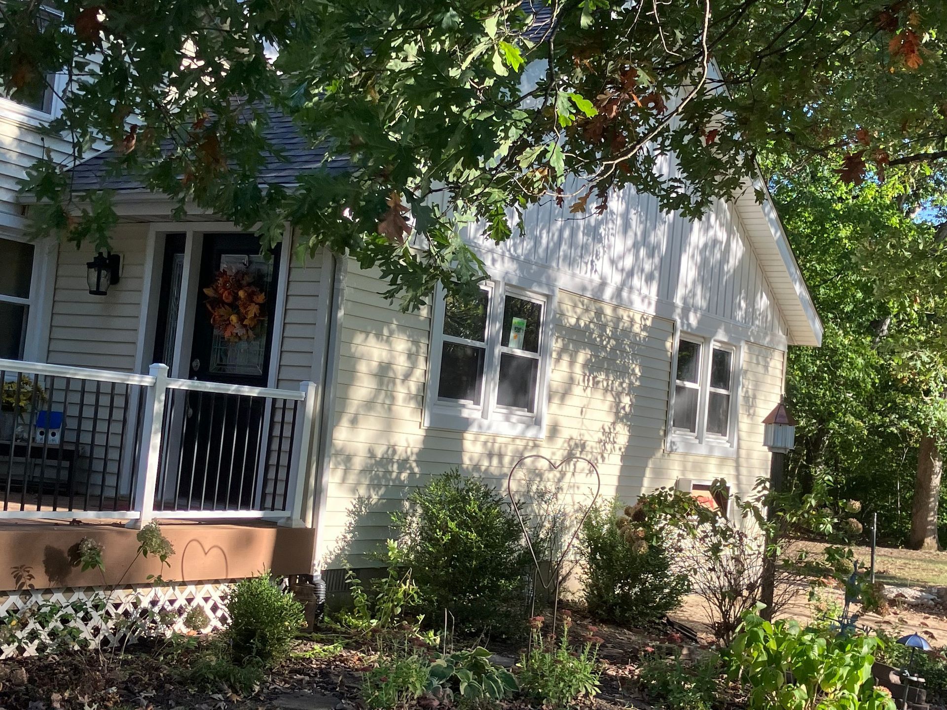A small white house with a porch and a sign that says 