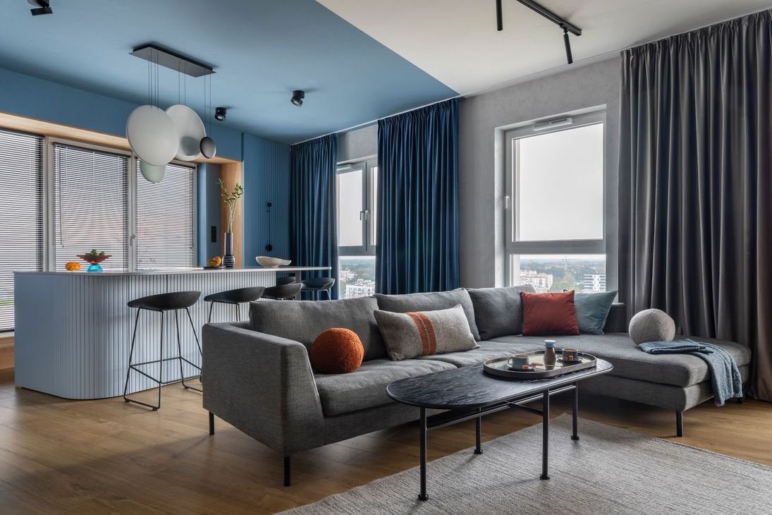 A living room with a couch , table , and curtains.