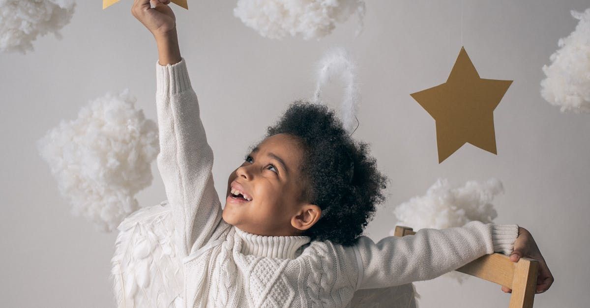 A young boy is holding a star in his hand and looking up at the sky.