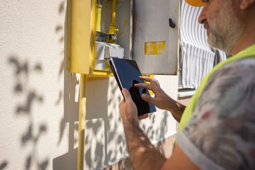 A Man Is Using A Tablet To Check A Gas Meter - Fort Worth, TX - Andress Plumbing