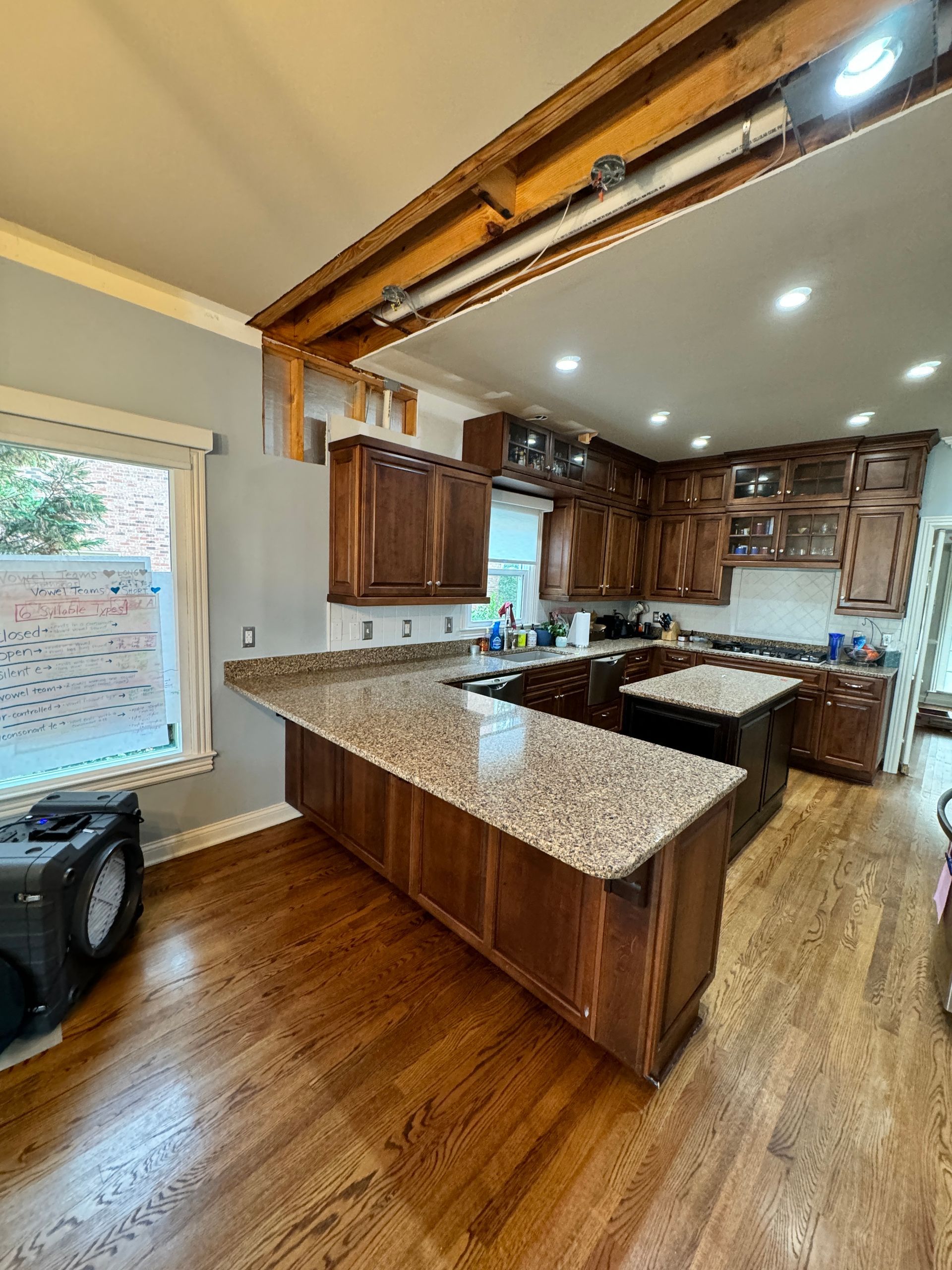 Kitchen with wood cabinets, granite countertops, and wood flooring.
