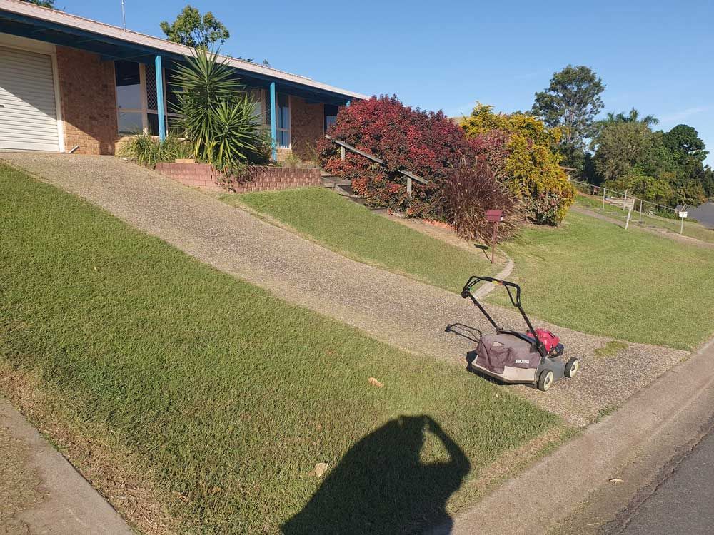 Lawn Mower Sitting on a Driveway — Professional Gardening Services in The Range, QLD